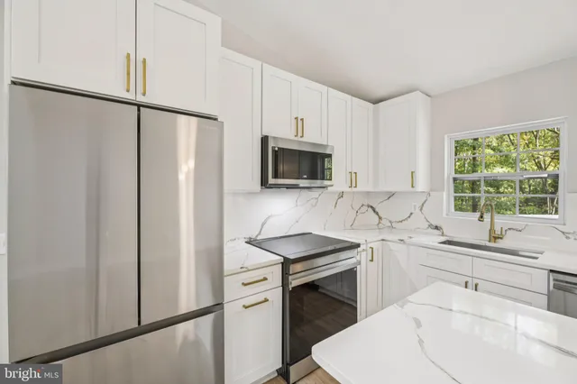 a kitchen with stainless steel appliances a sink stove and refrigerator