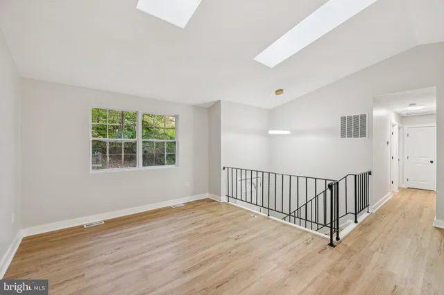 a view of a room with wooden floor and windows