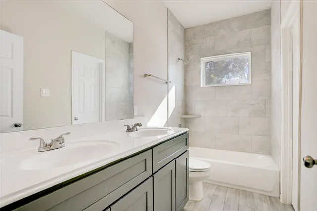 a bathroom with a granite countertop sink a toilet and a bathtub