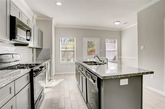 a kitchen with stainless steel appliances granite countertop a sink stove and refrigerator