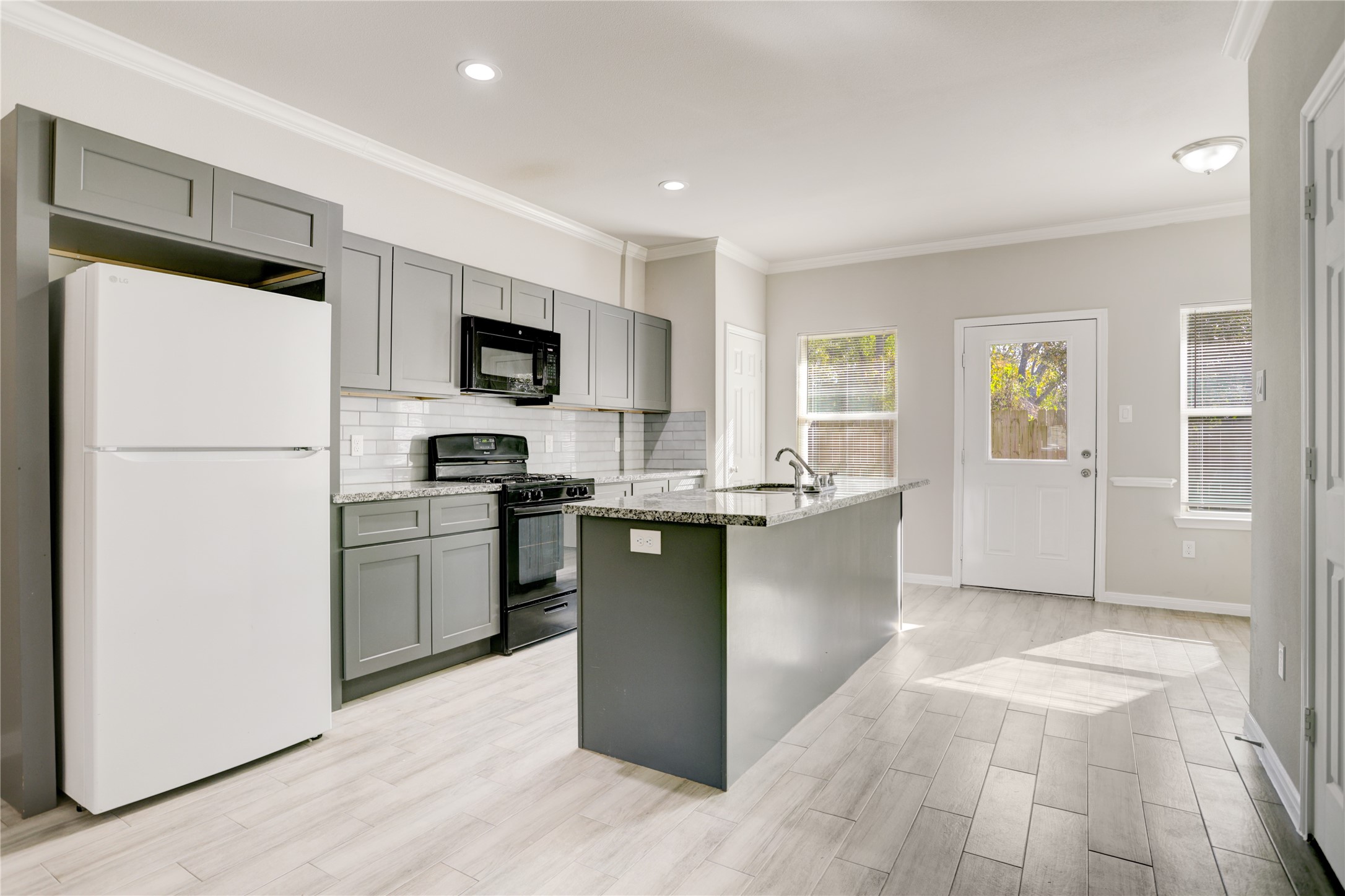 1045 Marcolin Street Houston, TX 77088 - Photo 3 of 16 a kitchen with granite countertop a refrigerator stove top oven and sink