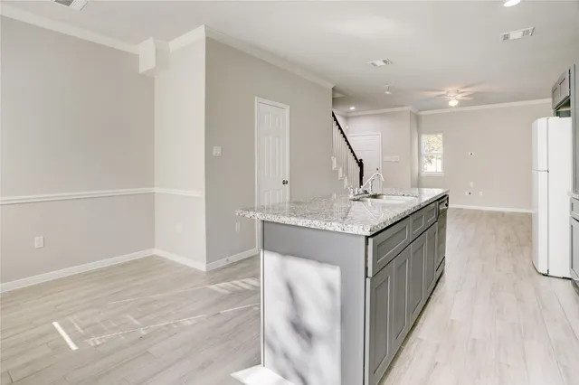 a kitchen with granite countertop a sink and a refrigerator