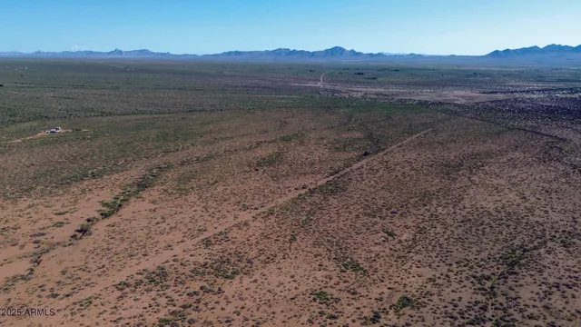 a view of a dry field with wooden fence