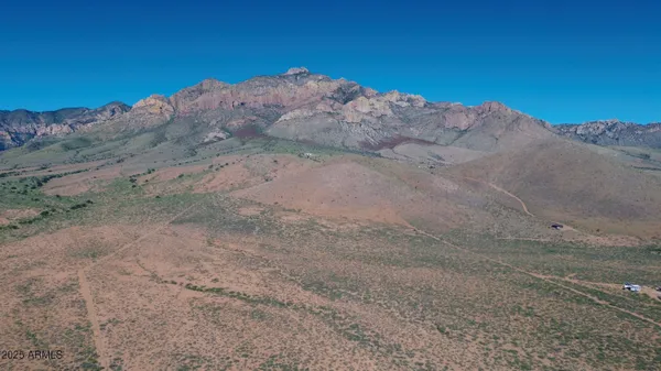 a view of a dry yard with mountains in the background