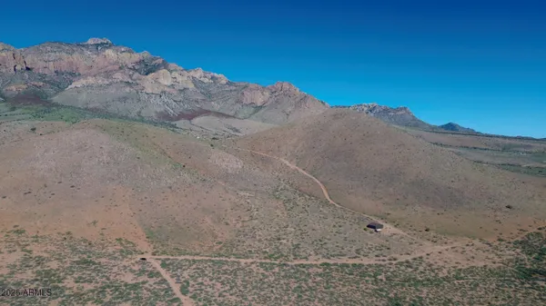 a view of a dry yard with mountains in the background