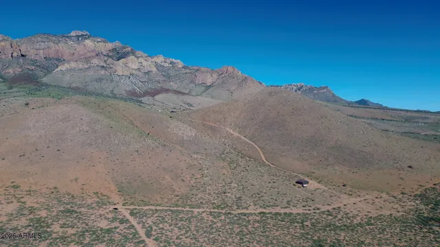 a view of a dry yard with mountains in the background