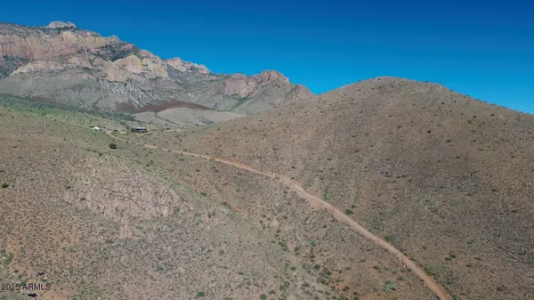 a view of a dry yard with mountains in the background