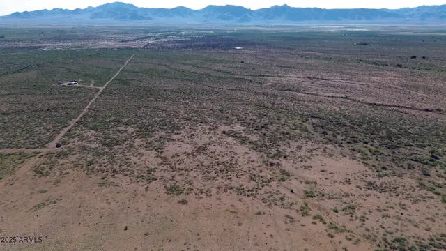 a view of a dry field with green space