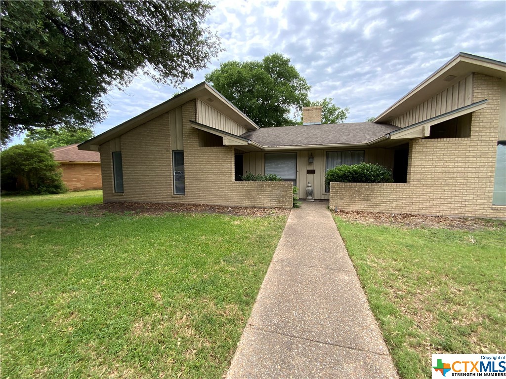a front view of house with yard and trees