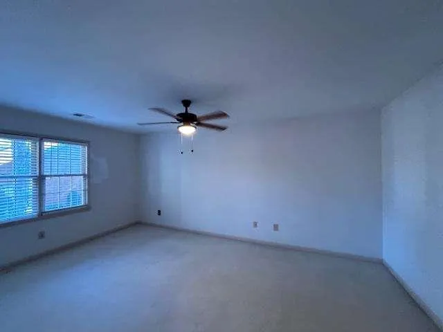 an empty room with a empty space and a ceiling fan
