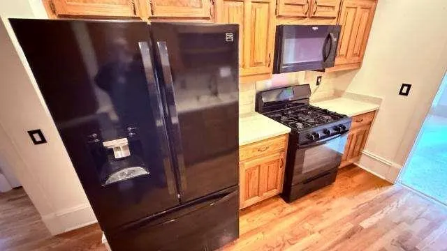 a kitchen with stainless steel appliances granite countertop a refrigerator and a stove top oven