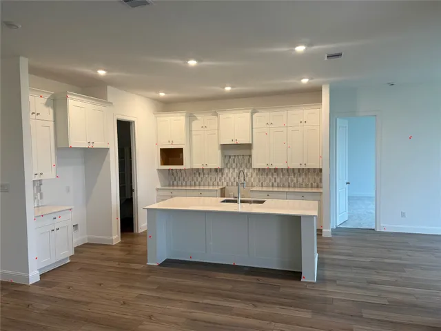 a large kitchen with stainless steel appliances a large counter top and a stove