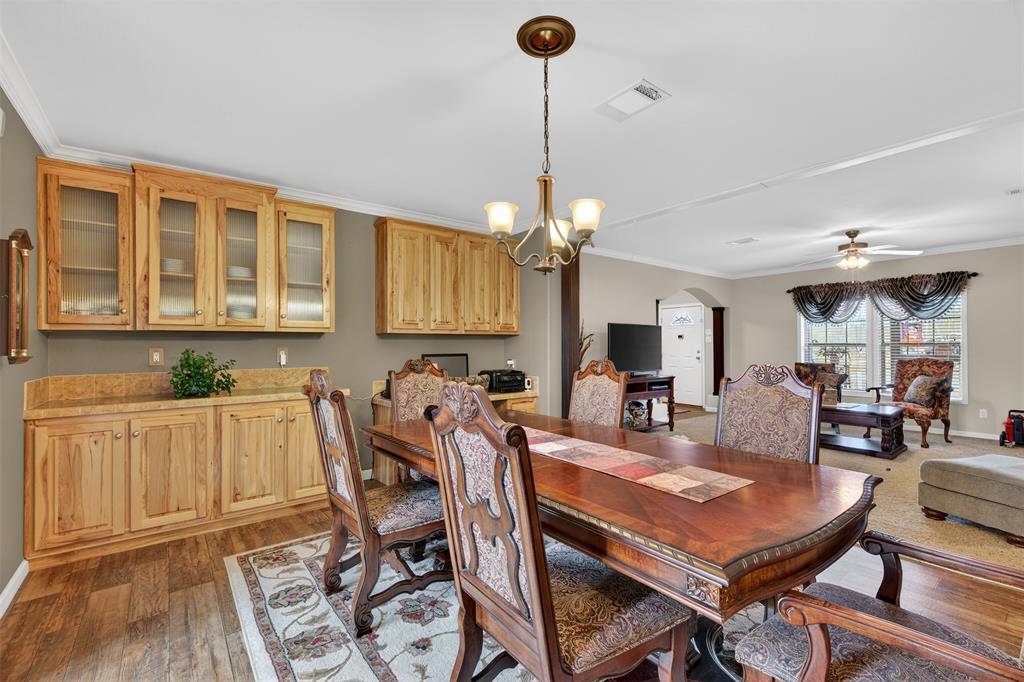 8794 Castle Dale Loop Shreveport, LA 71107 - Photo 11 of 31 Dining space featuring crown molding, arched walkways, light wood-style flooring, ceiling fan, and a chandelier