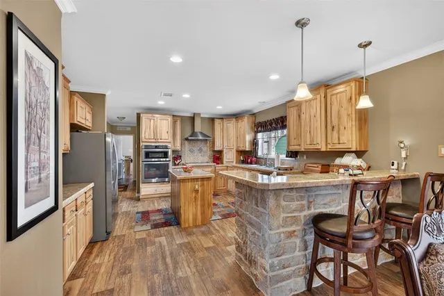 a kitchen with stainless steel appliances a stove refrigerator sink and cabinets