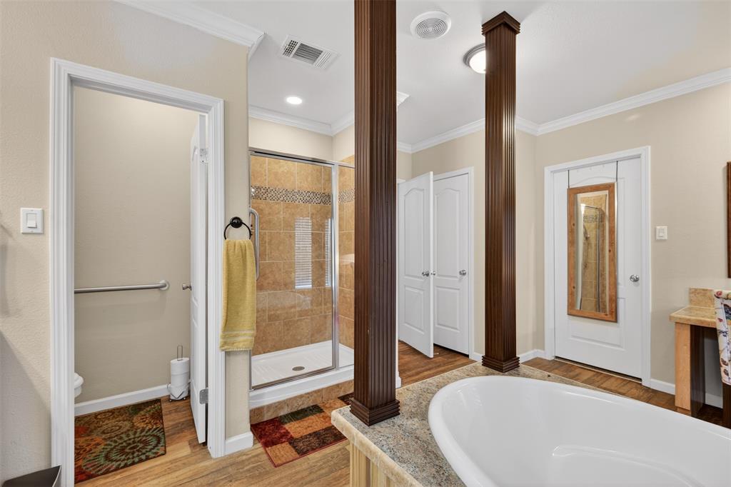 8794 Castle Dale Loop Shreveport, LA 71107 - Photo 21 of 31 Full bath with a stall shower, a garden tub, crown molding, light wood-type flooring, and vanity