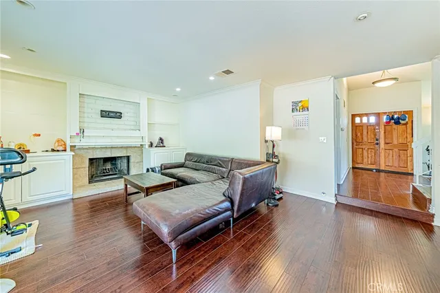 a living room with furniture fireplace and wooden floor