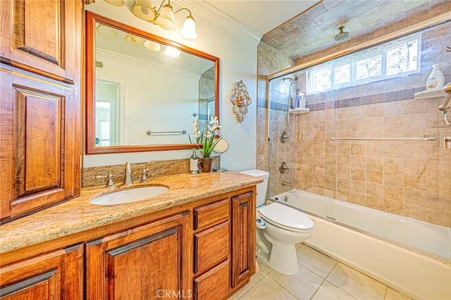 a bathroom with a granite countertop sink toilet mirror and bathtub