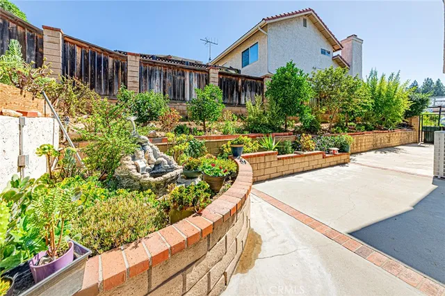 a front view of a house with a yard and potted plants