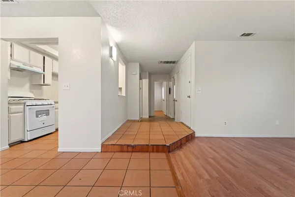 a view of a room with wooden floor and electronic appliances