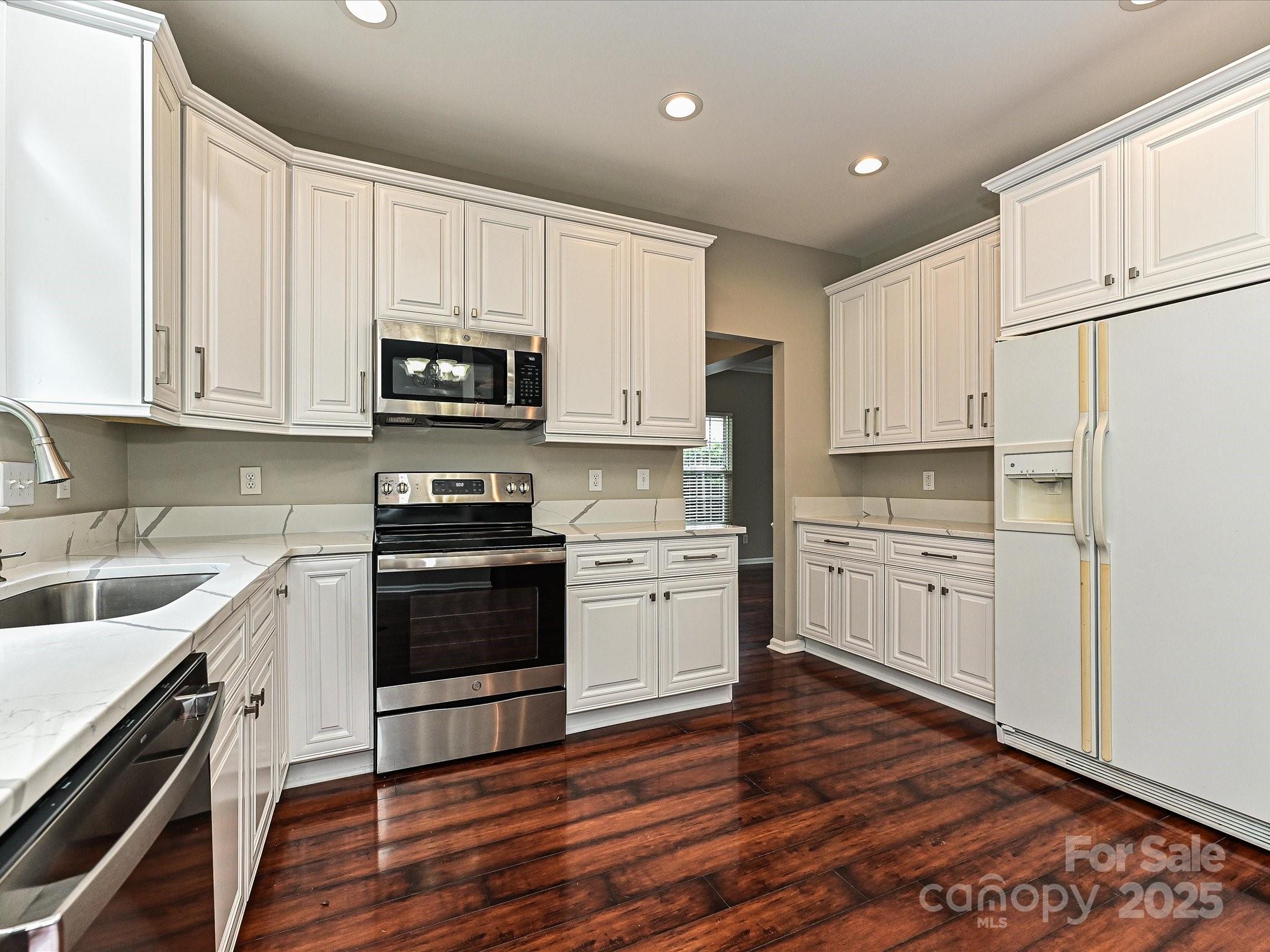 13237 Fremington Road Huntersville, NC 28078 - Photo 16 of 36 a kitchen with granite countertop white cabinets and white appliances