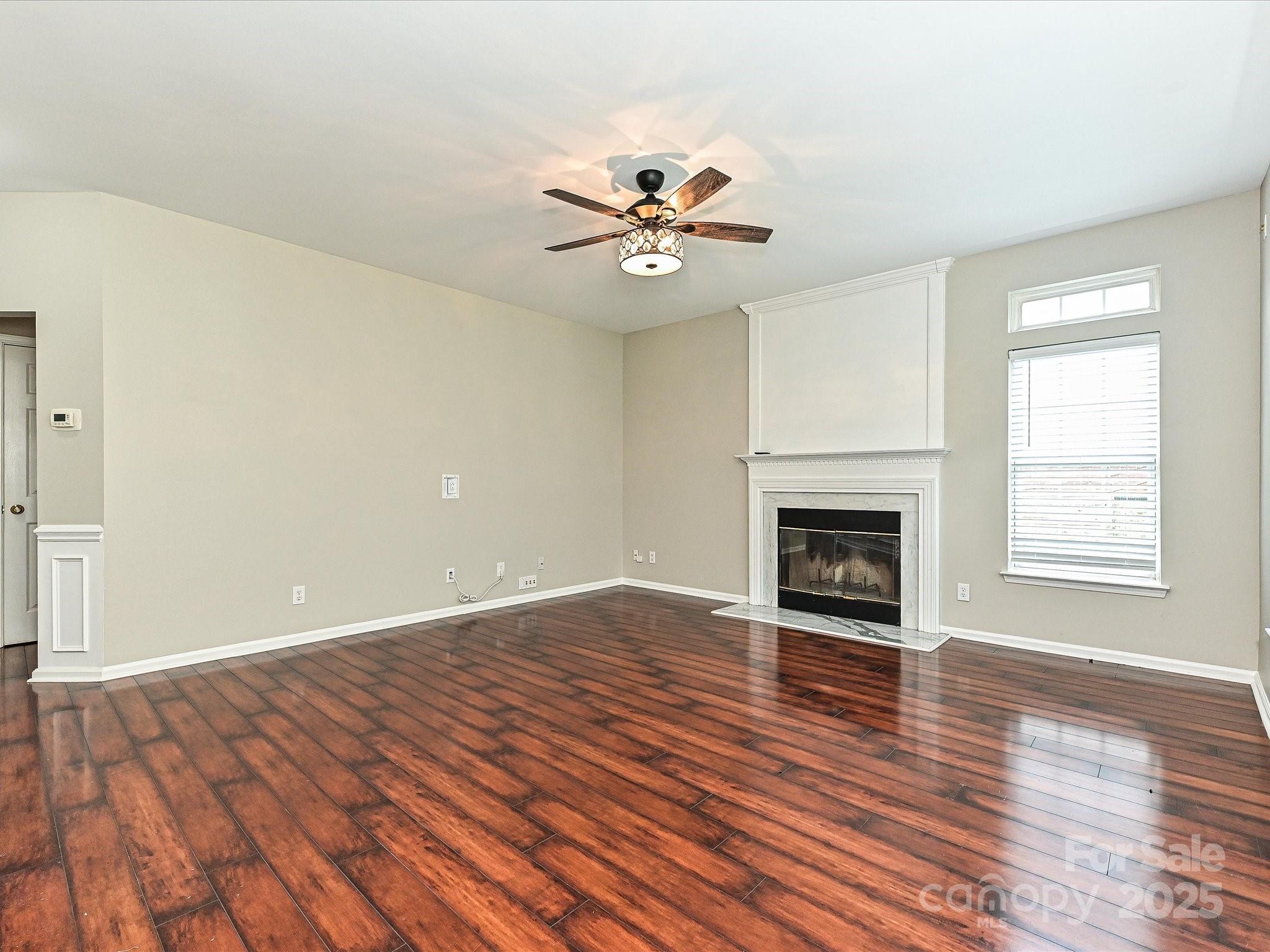 13237 Fremington Road Huntersville, NC 28078 - Photo 19 of 36 an empty room with a fireplace and wooden floor