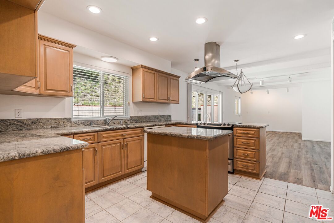 1181 Somera Road Los Angeles, CA 90077 - Photo 12 of 40 a kitchen with stainless steel appliances granite countertop a sink a stove and a refrigerator