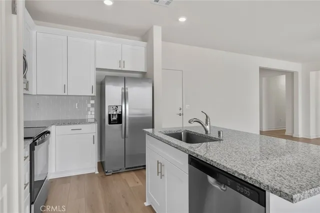 a kitchen with a sink a refrigerator and cabinets