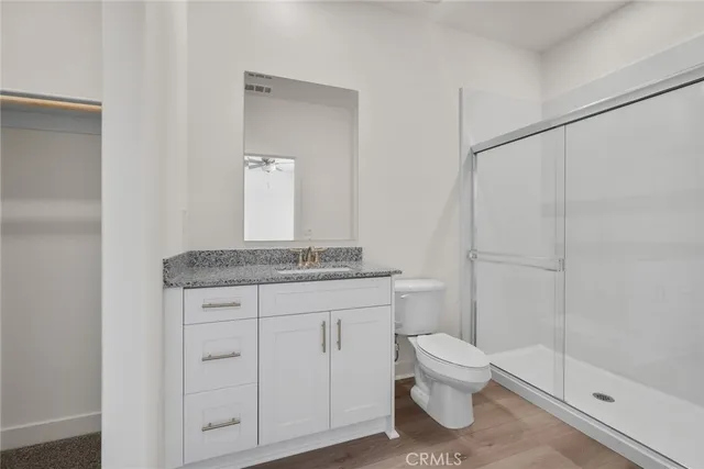 a bathroom with a granite countertop sink a toilet and shower