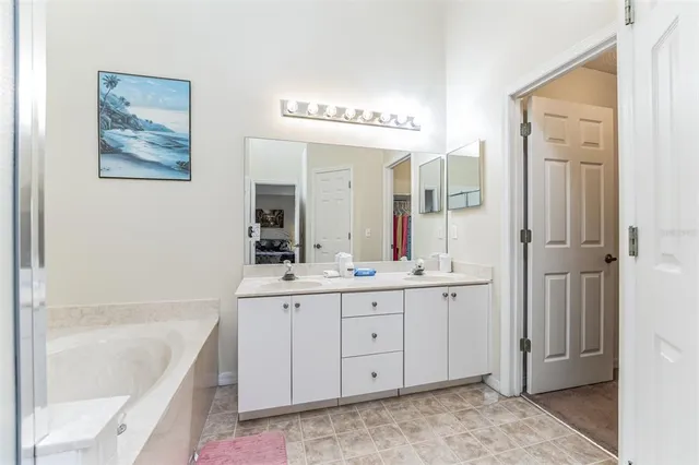 a spacious bathroom with a tub sink and mirror