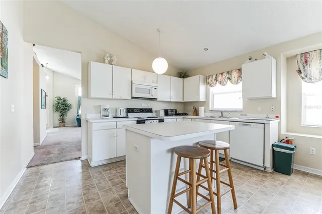 a kitchen with a table chairs sink and cabinets