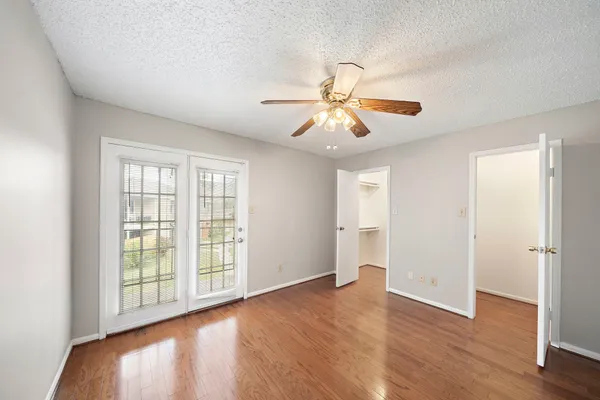 a view of an empty room with a window and wooden floor