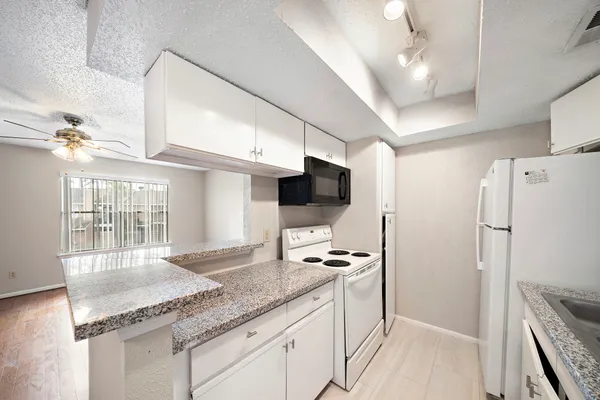 a kitchen with stainless steel appliances granite countertop a refrigerator a sink and a stove