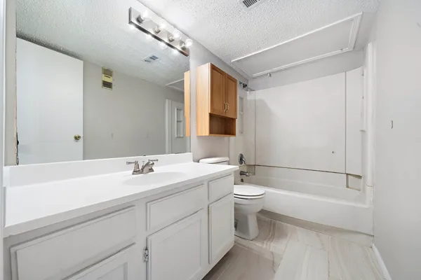 a bathroom with a double vanity sink toilet mirror and bathtub
