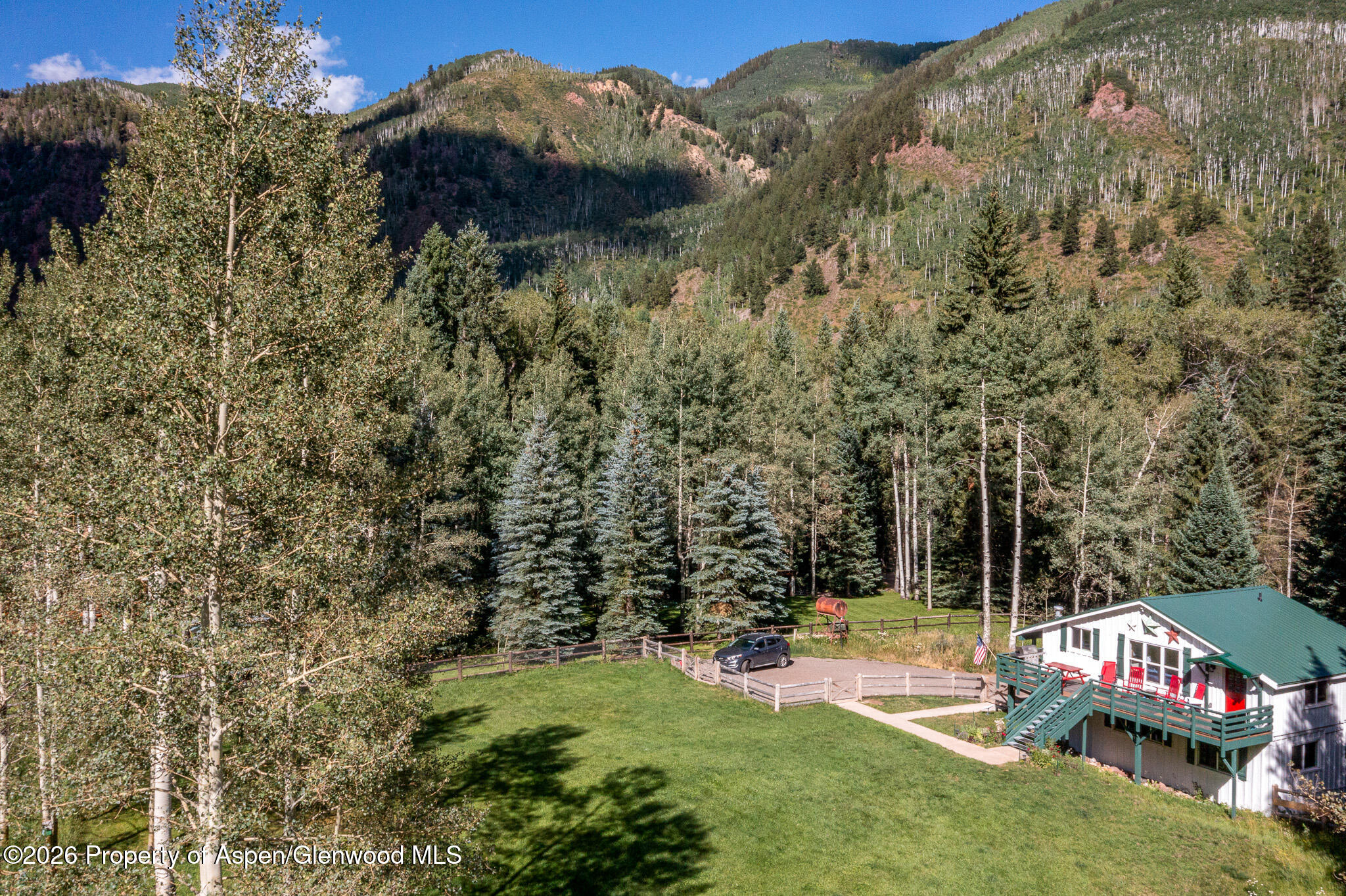 285 Conundrum Creek Road Aspen, CO 81611 - Photo 1 of 35 a view of a yard with flower garden and wooden fence