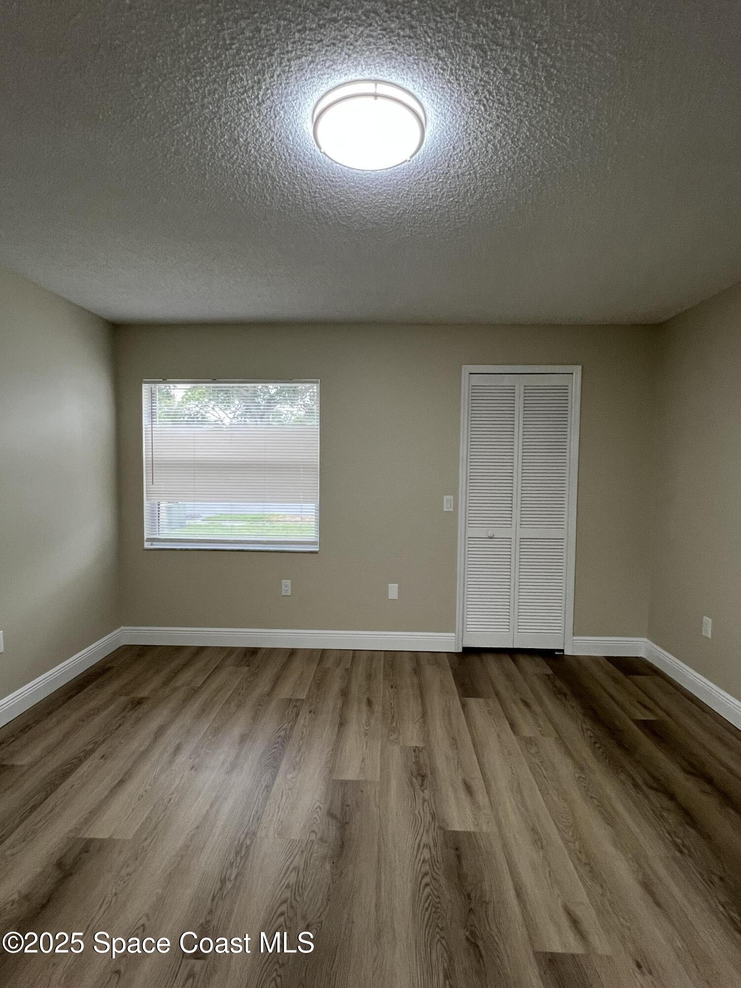 3154 Dunhill Drive Cocoa, FL 32926 - Photo 16 of 19 an empty room with wooden floor and windows