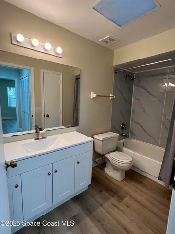 a bathroom with a toilet sink a mirror and shower