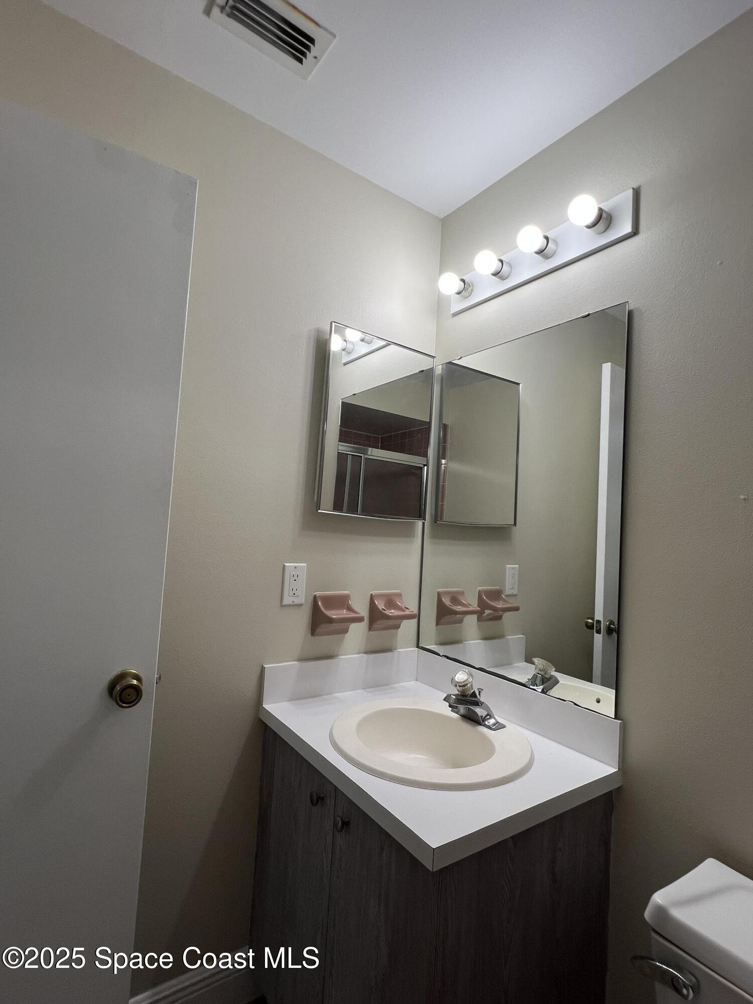 3154 Dunhill Drive Cocoa, FL 32926 - Photo 19 of 19 a bathroom with a sink and a mirror