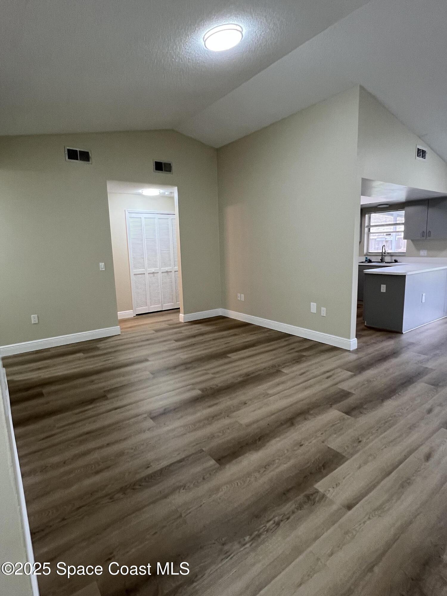 3154 Dunhill Drive Cocoa, FL 32926 - Photo 4 of 19 an empty room with wooden floor and windows