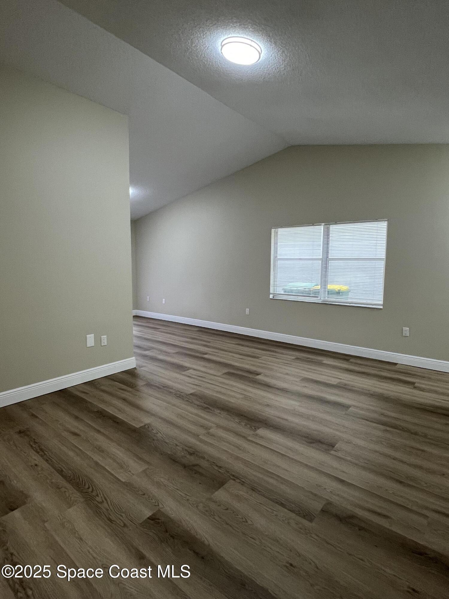 3154 Dunhill Drive Cocoa, FL 32926 - Photo 6 of 19 an empty room with wooden floor and windows