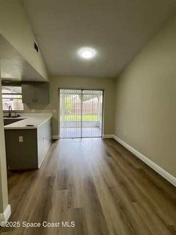 a view of a kitchen with a sink and wooden floor
