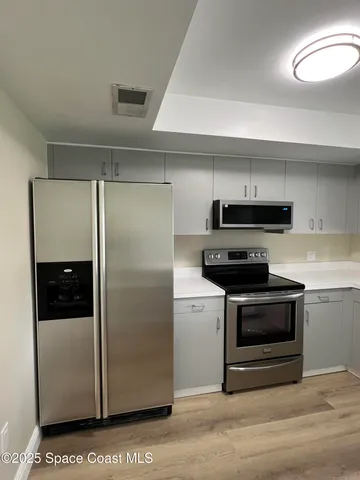 a kitchen with stainless steel appliances granite countertop a refrigerator and a stove