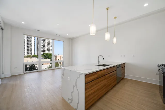 a living room with furniture kitchen view and a potted plant