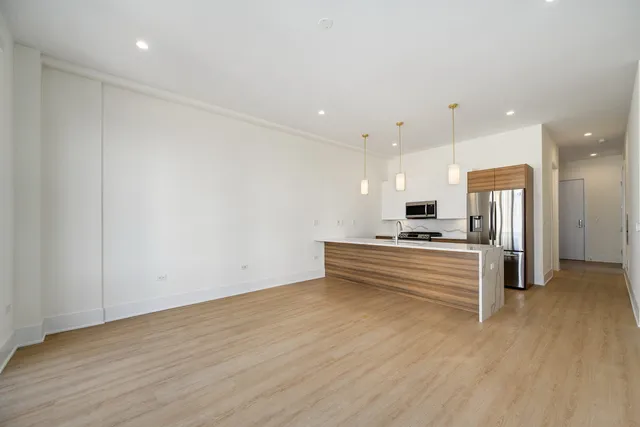 a kitchen with stainless steel appliances granite countertop a sink and a refrigerator