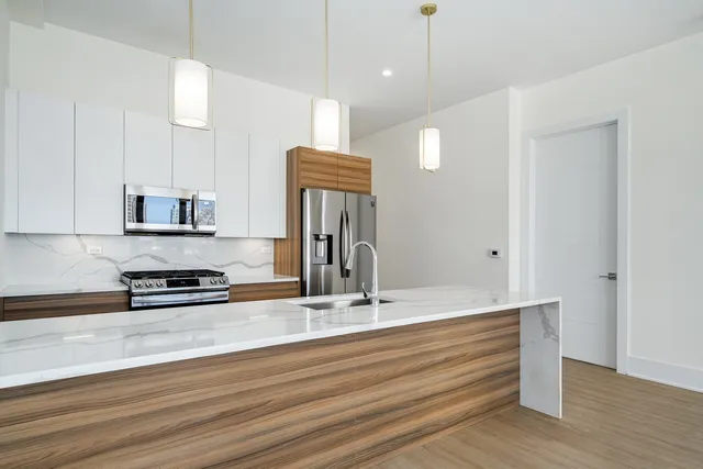 a kitchen with stainless steel appliances granite countertop a sink stove and refrigerator