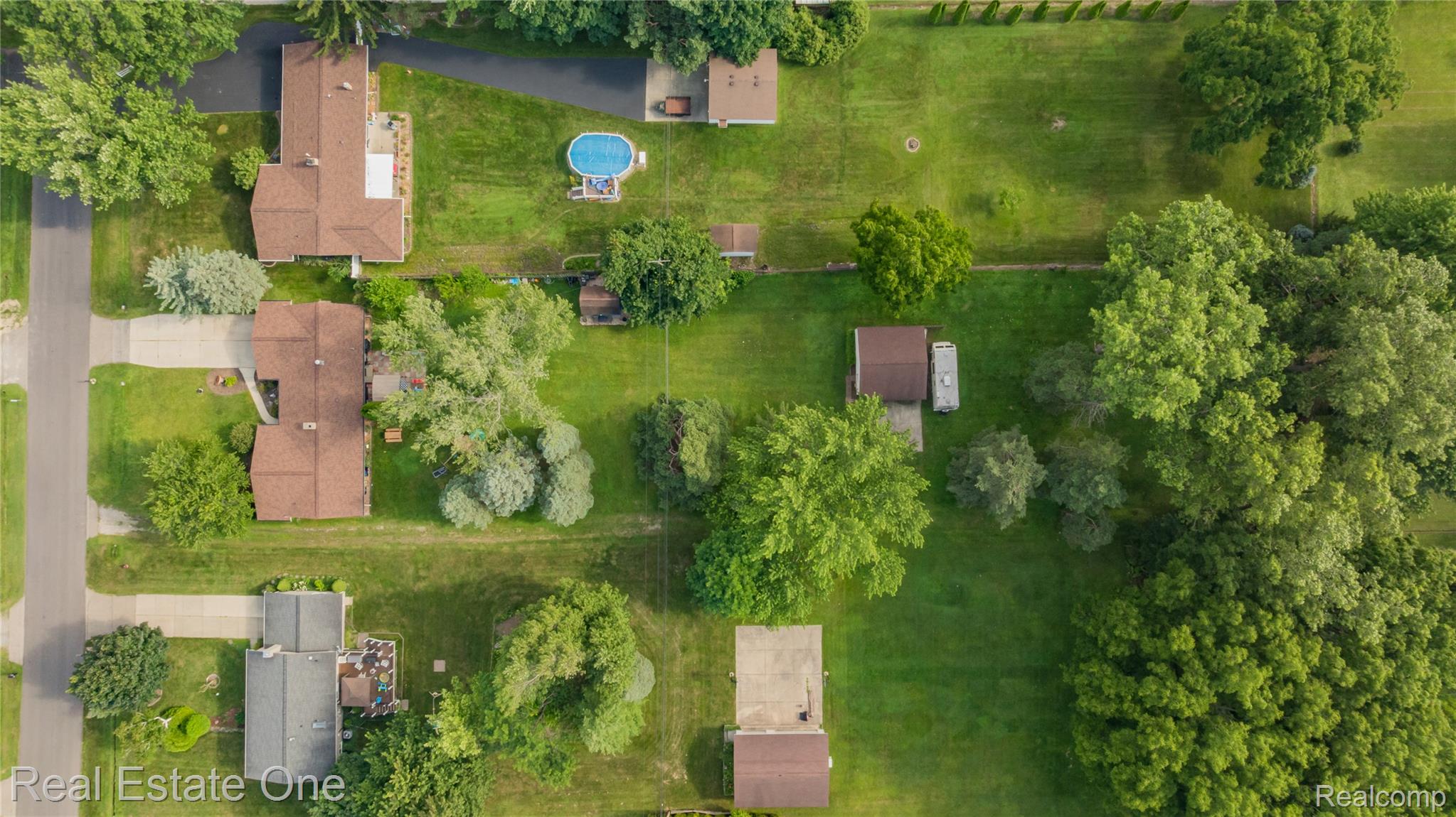2810 Walbridge Drive Rochester, MI 48307 - Photo 52 of 58 Expansive property offering considerable green space and mature trees, featuring a brown-roofed residence, paved driveway, and an above-ground pool