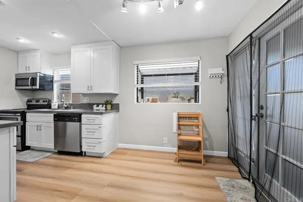 a kitchen with granite countertop a stove top oven and cabinets