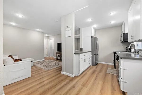 a large white kitchen with cabinets a sink and stainless steel appliances