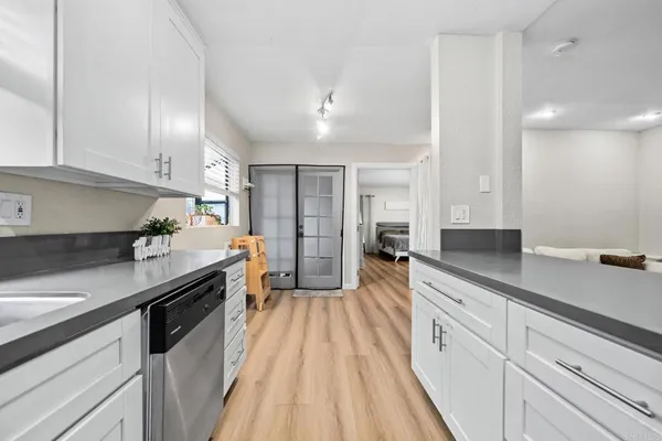 a kitchen with granite countertop a sink a counter space stainless steel appliances and cabinets