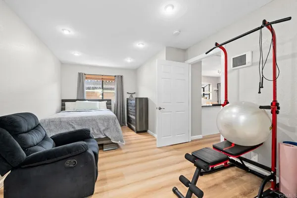 a bedroom with a bed and wooden floor