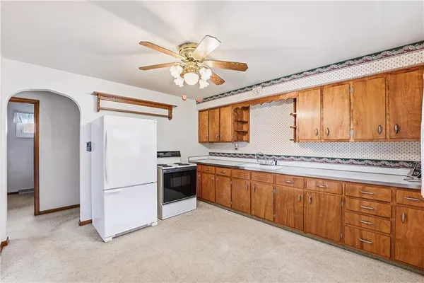 a kitchen with stainless steel appliances granite countertop a refrigerator a sink dishwasher a stove with white cabinets and wooden floor